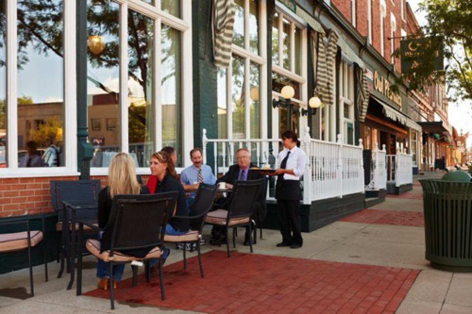 Waiter serving customers on outdoor patio